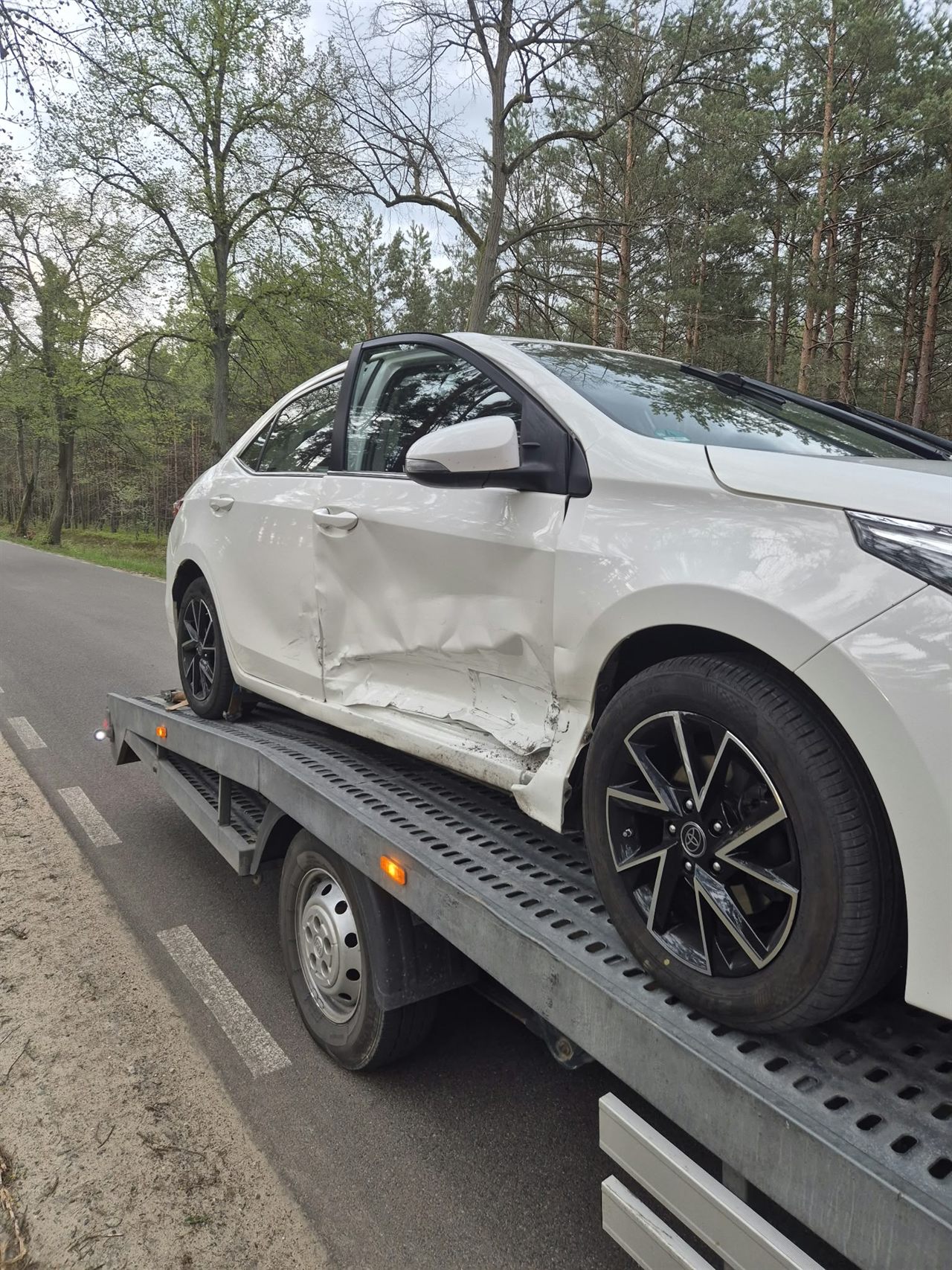 Uszkodzony samochód przewożony na lawecie AUTO JACA